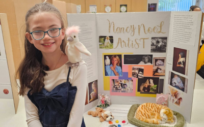 Young girl with cockatoo at Nancy Noel artist display
