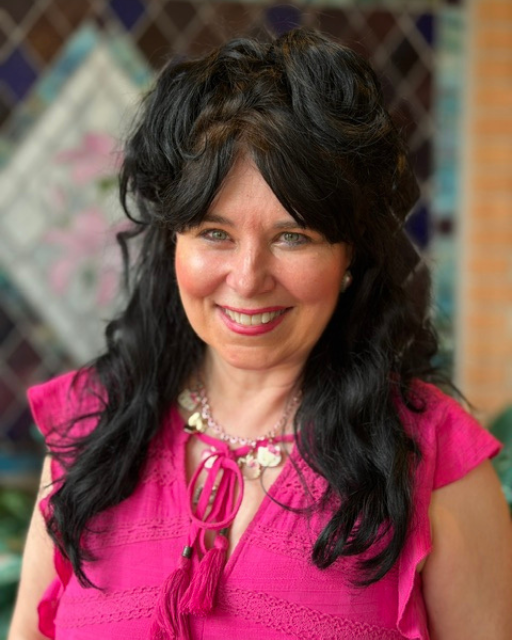 JoAnn Dellenger smiles in a bright pink top.