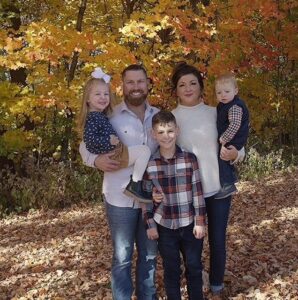 Family portrait with fall foliage behind them