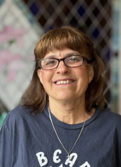 Marta Laubenstein smiles wearing a navy t-shirt with text